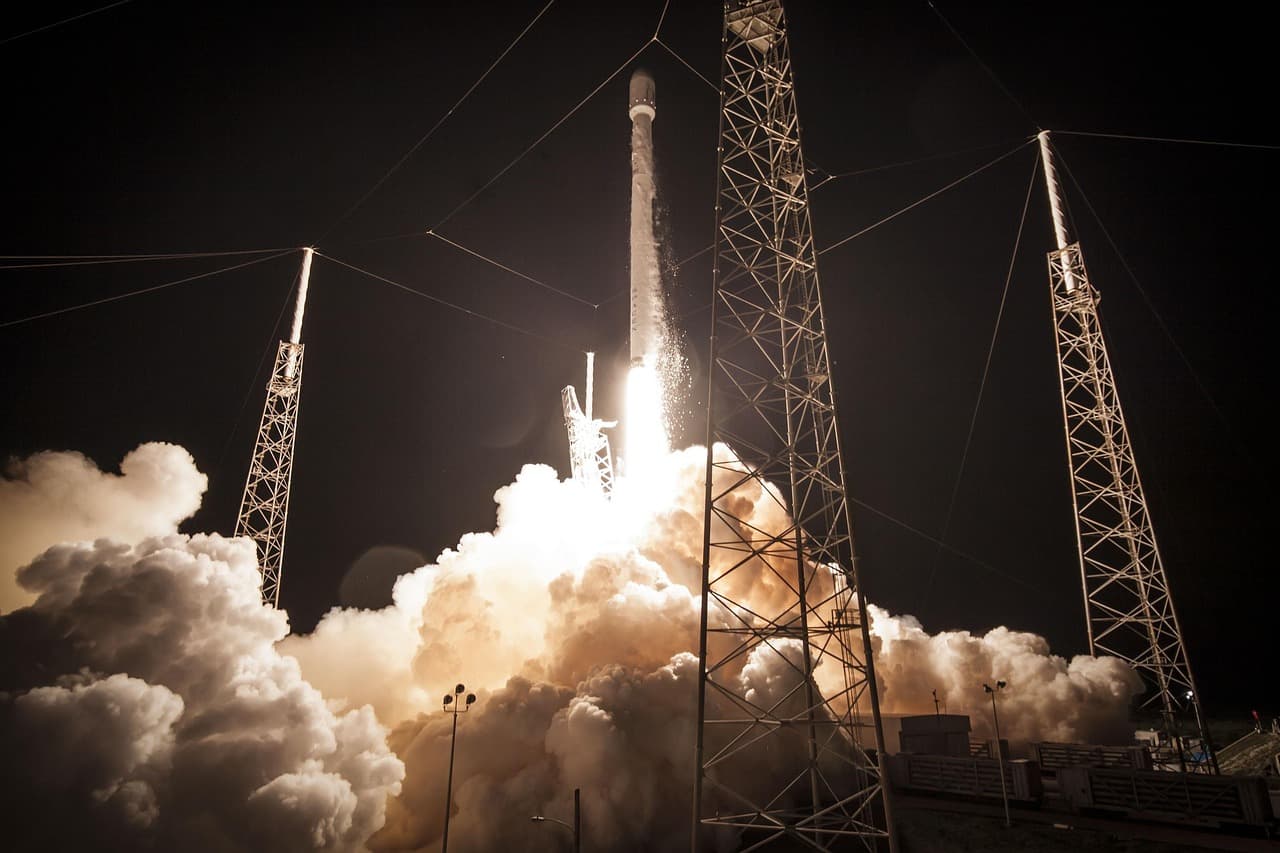 A rocket lifting off from its launch pad at night